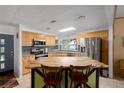 Bright kitchen showcasing a butcher block island, stainless steel appliances, and serene lake views at 8467 Imperial Cir, Palmetto, FL 34221