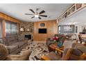 Inviting living room featuring a decorative fireplace, wood paneling, and comfortable seating at 8467 Imperial Cir, Palmetto, FL 34221