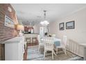 Cozy dining room with white furnishings and a decorative brick accent wall at 8827 White Sage Loop, Lakewood Ranch, FL 34202