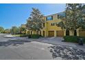 Townhome exterior showing garages, landscaping, and yellow facade at 8827 White Sage Loop, Lakewood Ranch, FL 34202