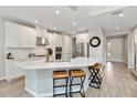 Modern kitchen features white cabinets, subway tile backsplash, stainless steel appliances, and quartz countertop island at 9061 Luna Ln, Sarasota, FL 34241