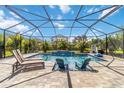 Stunning screened-in pool with waterfall feature, lounge chairs, and lush landscaping, perfect for relaxation at 9061 Luna Ln, Sarasota, FL 34241