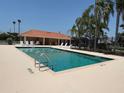 Outdoor swimming pool with metal ladders and clear water, surrounded by a concrete deck and lounge chairs at 3724 71St E Ter, Sarasota, FL 34243