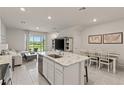 Bright, open-concept kitchen features a center island with marble countertops and modern appliances at 17620 Crescent Moon Loop, Bradenton, FL 34211