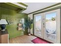 Bright entryway with decorative wreath, wood-paneled wall, and stylish double doors leading outside at 2105 Georgia Ave, Englewood, FL 34224