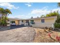 Inviting single-story home with a covered carport, decorative white fencing, and a double-door entryway at 2105 Georgia Ave, Englewood, FL 34224