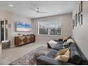 Comfortable living room with a large gray sectional, mounted TV, and neutral tile flooring at 232 Explorer Dr # 15, Osprey, FL 34229