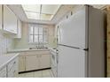 Bright kitchen features white cabinets, countertops, and appliances, with a skylight and tiled floor at 2819 Swifton Dr # 9, Sarasota, FL 34231