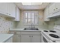 Bright kitchen features white cabinets, countertops, and appliances, and a window with lots of natural light at 2819 Swifton Dr # 9, Sarasota, FL 34231