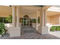 Elegant building entrance with prominent columns, leading to a glass door entryway and lush landscaping at 3080 Grand Bay Blvd # 533, Longboat Key, FL 34228