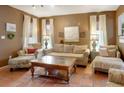 Comfortable living room with warm neutral color scheme is filled with natural light from large windows and stylish decor at 316 29Th W St, Bradenton, FL 34205