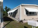 Tan mobile home featuring awnings for sun protection at 320 Tropic Dr, Osprey, FL 34229