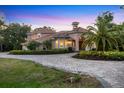 Beautiful two-story home with a clay tile roof and manicured greenery at 3905 Trentwood Pl, Sarasota, FL 34243