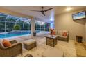 Inviting outdoor patio with comfortable seating, ceiling fan, and a view of the sparkling pool at 3905 Trentwood Pl, Sarasota, FL 34243