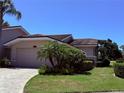 Charming one-story home with a paver driveway, a two-car garage, lush landscaping, and a beautiful tile roof at 4044 Penshurst Park, Sarasota, FL 34235