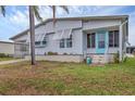 Single-story home with awning-covered windows, a turquoise front door, and cozy landscaping at 4312 14Th E St, Ellenton, FL 34222