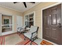 Inviting screened porch with seating, a welcome mat and view of the entry door at 4802 51St W St # 704, Bradenton, FL 34210