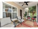 Relaxing screened porch with neutral furniture, ceiling fan, rug, and views of tropical landscaping at 4802 51St W St # 704, Bradenton, FL 34210