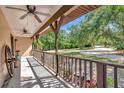 Covered porch with ceiling fans, decorative wagon wheel, and a beautiful view of the yard at 4876 253Rd E St, Myakka City, FL 34251