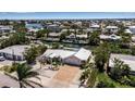 Aerial view of a waterfront home with lush greenery, dock, and access to the bay at 519 74Th St, Holmes Beach, FL 34217