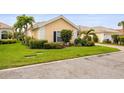 Beautiful home exterior featuring a manicured lawn, blooming shrubbery, and an inviting facade at 5751 Wilena Pl, Sarasota, FL 34238
