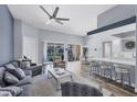 Spacious living room featuring vaulted ceiling, bar seating, and sliding glass doors to the patio at 5881 Girona Pl, Sarasota, FL 34238