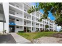 Multi-story building featuring multiple balconies, well-maintained landscaping, and inviting curb appeal at 600 Sutton Pl # B305, Longboat Key, FL 34228