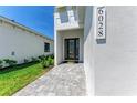 Clean, modern home entrance with brick paver walkway and clearly displayed address number for easy visibility at 6028 Cat Claw Ln, Bradenton, FL 34210
