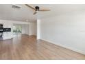 Bright living room featuring sleek wood floors, fresh white paint, and modern ceiling fan at 609 Glen Oak Rd, Venice, FL 34293