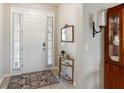 Close up of the home's tiled entryway, featuring a white door, a small table and view of dining room at 6124 35Th E Ct, Bradenton, FL 34203