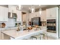 Bright, modern kitchen with white cabinets, stainless steel appliances, and a spacious center island at 7048 Foxboro Way, Nokomis, FL 34275