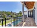 Balcony view overlooking a backyard pool, with wood floors and a white pillar at 7142 Hawks Harbor Cir, Bradenton, FL 34207