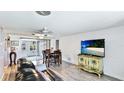 Cozy living room with wood flooring, a ceiling fan, and access to the outdoors through sliding glass doors at 959 Cumberland Rd, Venice, FL 34293