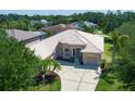 Aerial view of a charming single-story home featuring a tile roof, well-kept landscaping, and a spacious driveway at 11458 30Th E Cv, Parrish, FL 34219