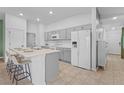 Bright kitchen boasts an island with seating and sleek gray cabinetry and appliances at 11571 Little River Way, Parrish, FL 34219