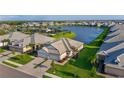 Exterior elevation of a white home with a two-car garage, lush lawn, and manicured landscaping at 17827 Cherished Loop, Lakewood Ranch, FL 34211