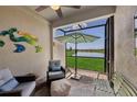 Cozy screened-in lanai with comfortable seating, an umbrella table, and views of the water at 17827 Cherished Loop, Lakewood Ranch, FL 34211