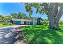 Charming single-story house with beautiful lawn and mature tree offering shade; attached garage adds convenience and appeal at 1809 67Th W St, Bradenton, FL 34209