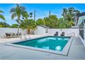 Refreshing pool area with lounge seating, palm trees, and white fence at 1921 Fern Ave, Sarasota, FL 34235