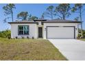 Charming single-story home with a two-car garage, dark trim and neutral stucco at 2290 Beeville Ave, North Port, FL 34286