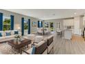 Open-concept living room and dining area with lots of natural light and hardwood floors at 2290 Beeville Ave, North Port, FL 34286