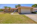 Welcoming home featuring a two-car garage, manicured lawn, and inviting front entrance at 2536 Carlisle Pl, Sarasota, FL 34231