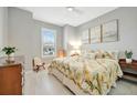 Cozy bedroom with light gray walls, tile flooring, and a sunny window view at 27061 Paradise Shores Dr, Englewood, FL 34223