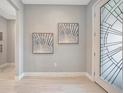 Bright entryway featuring tile flooring, decorative art, and front door with glass design at 27061 Paradise Shores Dr, Englewood, FL 34223