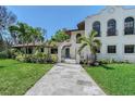 Charming home featuring an arched gate and blue front door amidst lush landscaping at 2833 Bay Shore Cir, Sarasota, FL 34234