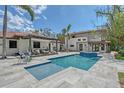A beautiful pool with a sunning area and an outdoor seating area covered by a trellis at 2833 Bay Shore Cir, Sarasota, FL 34234
