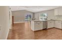 Bright kitchen featuring white cabinets, an island with seating, stainless steel appliances, and wood-look flooring at 3647 Country Place Blvd, Sarasota, FL 34233