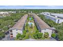 Aerial view showcasing the complex buildings, verdant landscaping and sparkling community pool at 3751 S School Ave # 19, Sarasota, FL 34239