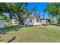 Expansive backyard offers ample green space, mature trees, and a screened-in porch for outdoor enjoyment at 409 Olive Ave, Nokomis, FL 34275