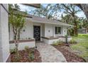 Inviting front entrance with a decorative door and well-maintained landscaping, creating curb appeal at 4916 Hidden Oaks Trl, Sarasota, FL 34232
